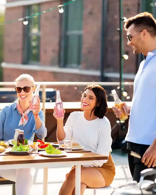 A group of people are sitting at a table eating and drinking.