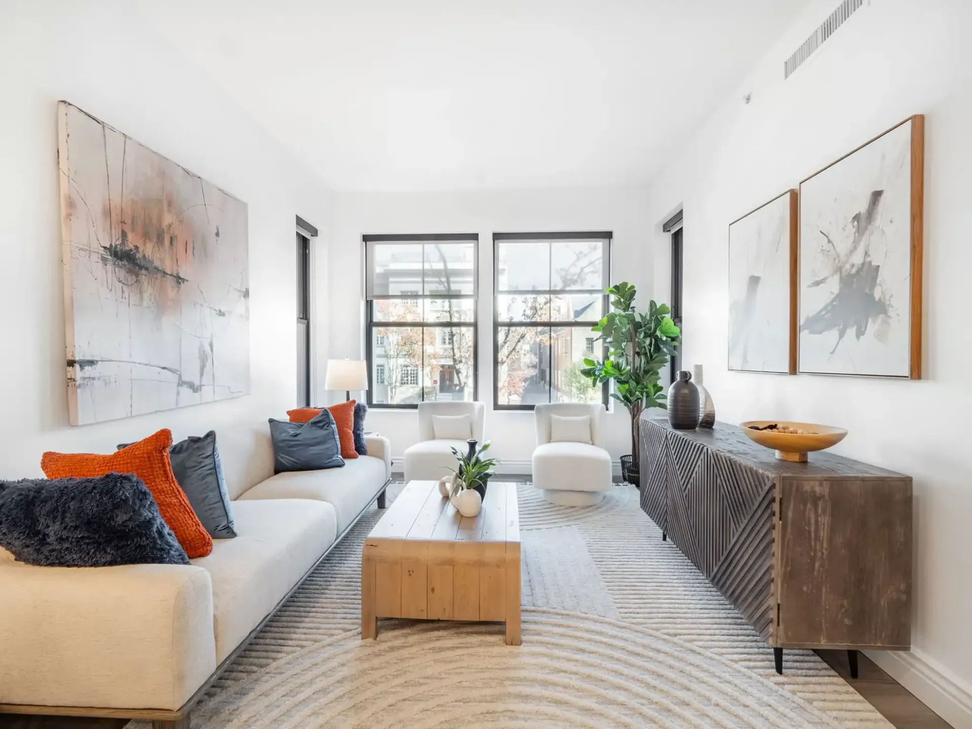 A living room with a white couch and a wooden coffee table