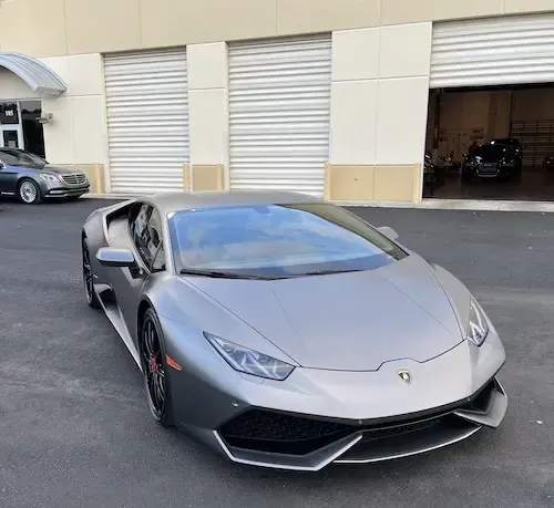 A gray lamborghini huracan is parked in front of a garage | Redline Automotive