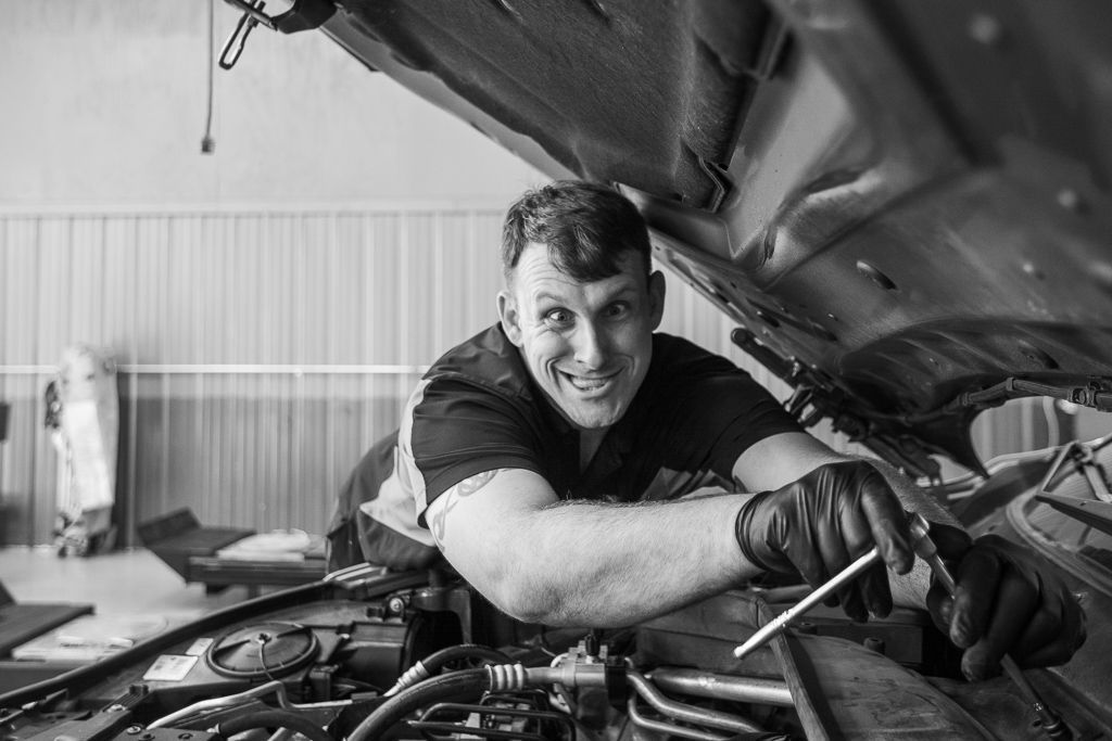 A man is working under the hood of a car. | Redline Automotive