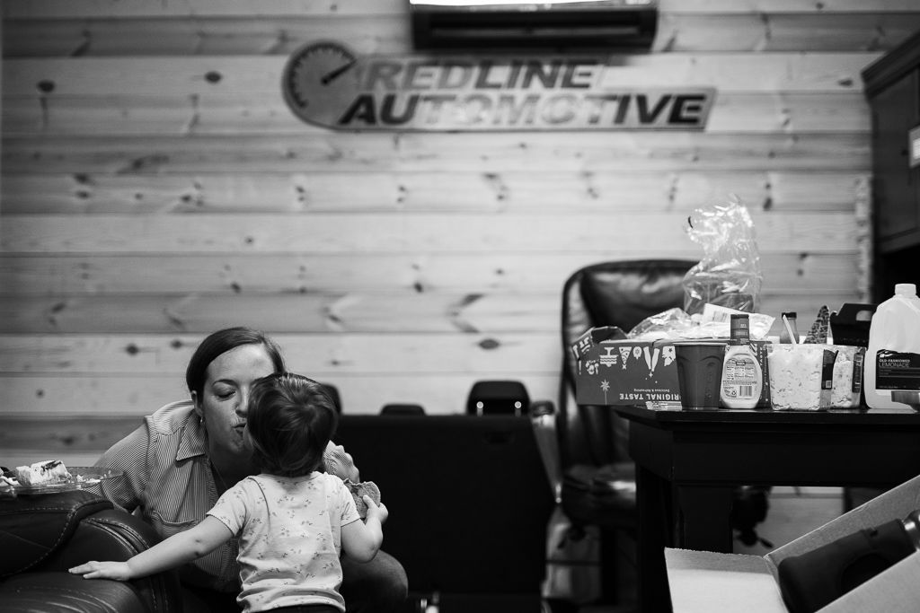 Black and white photo of a woman and child in an auto shop waiting room | Redline Automotive