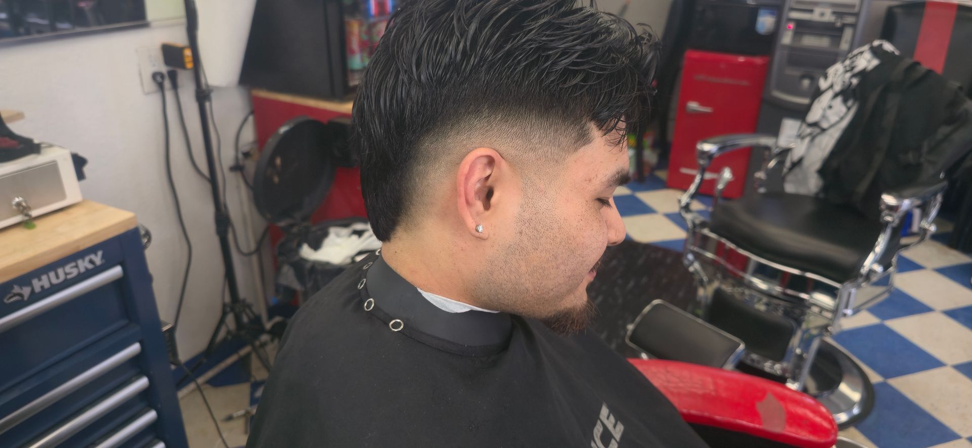 A Man Is Getting His Hair Cut At A Barber Shop