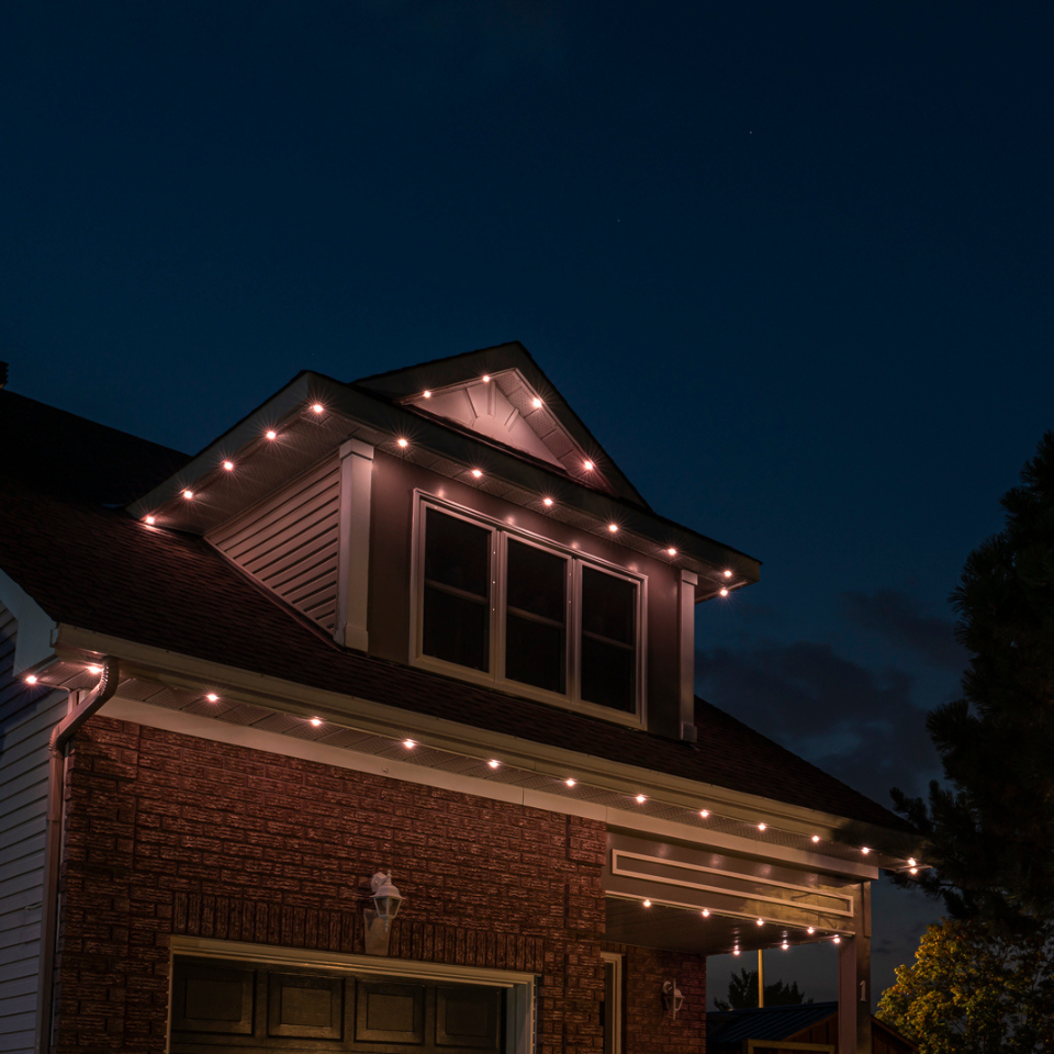 A brick house with lights on the roof at night