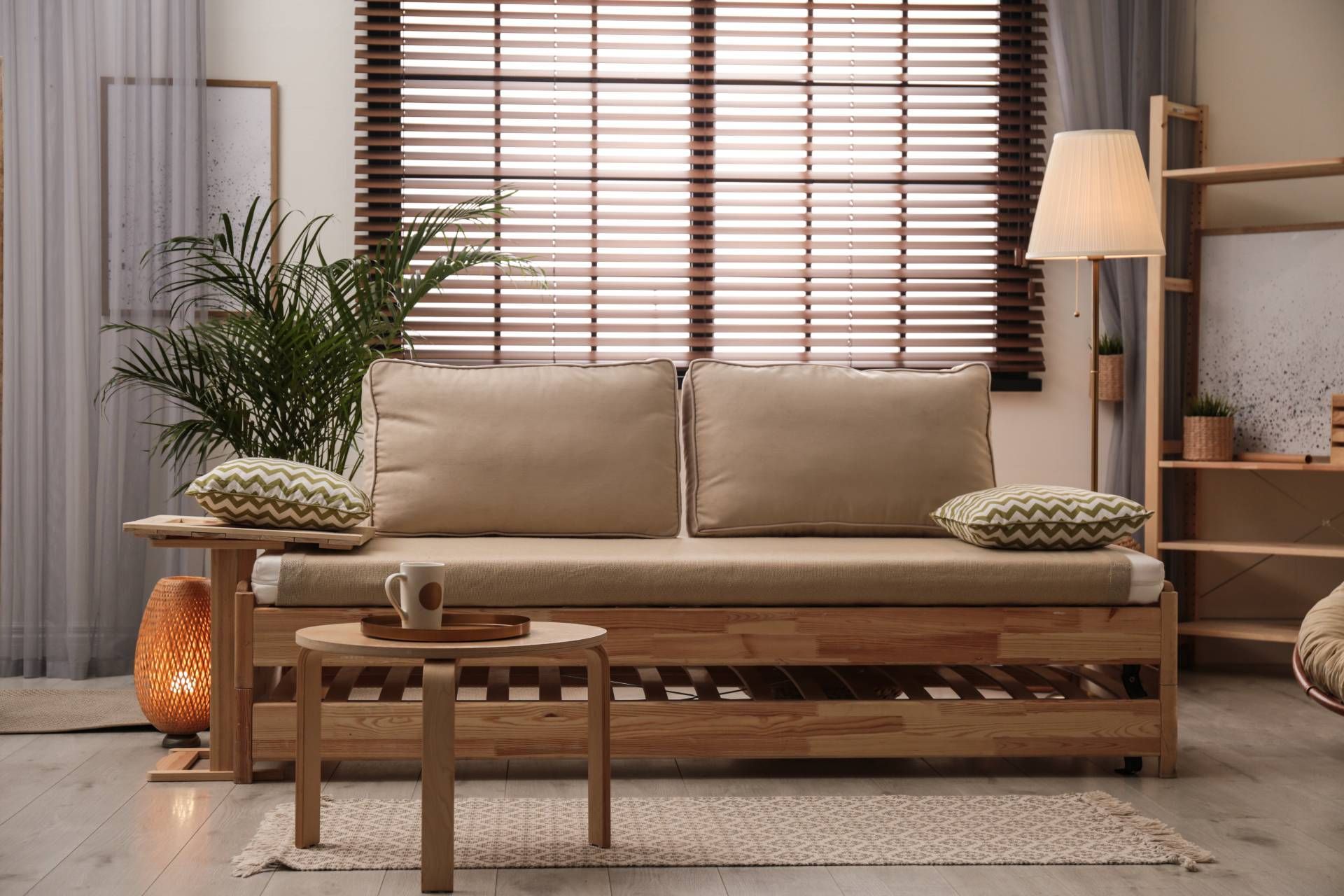 A living room with a large central window and blinds to keep it cool