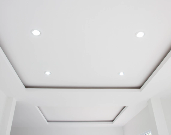 White ceiling with recessed lighting and two rectangular insets.