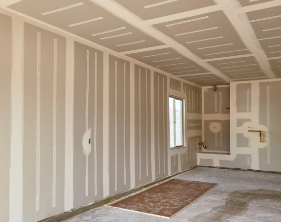 Interior with unfinished drywall walls and ceiling. Drywall seams taped and ready for finishing.