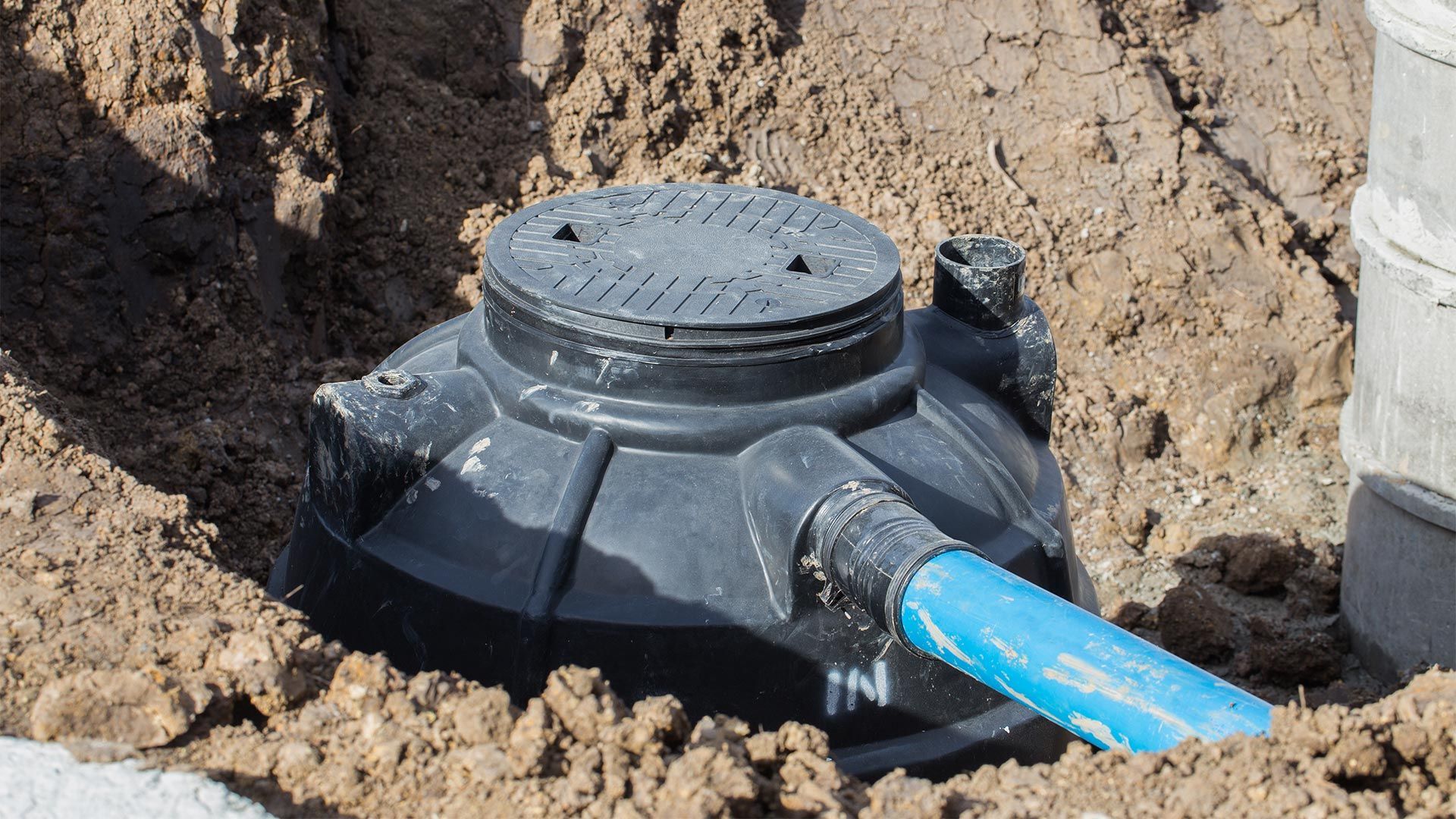 A septic tank is being installed in a hole in the ground.
