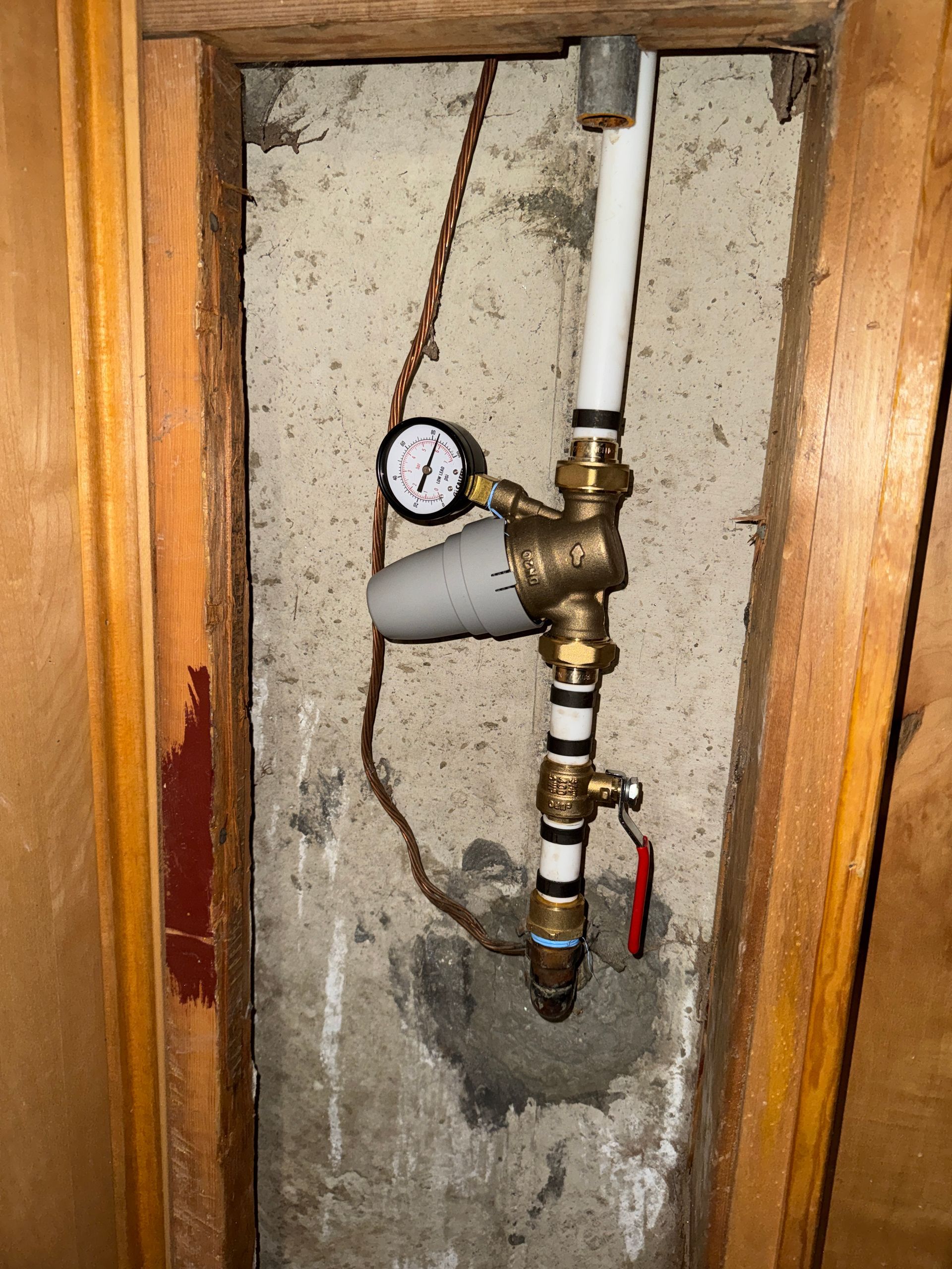 Pressure gauge and brass pressure reducing valve on a Utah home's main water line