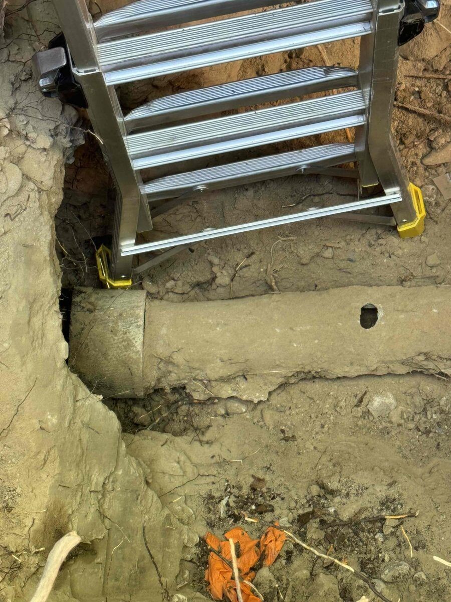 Dug-up old sewer pipe with a hole found during a Rare Breed inspection