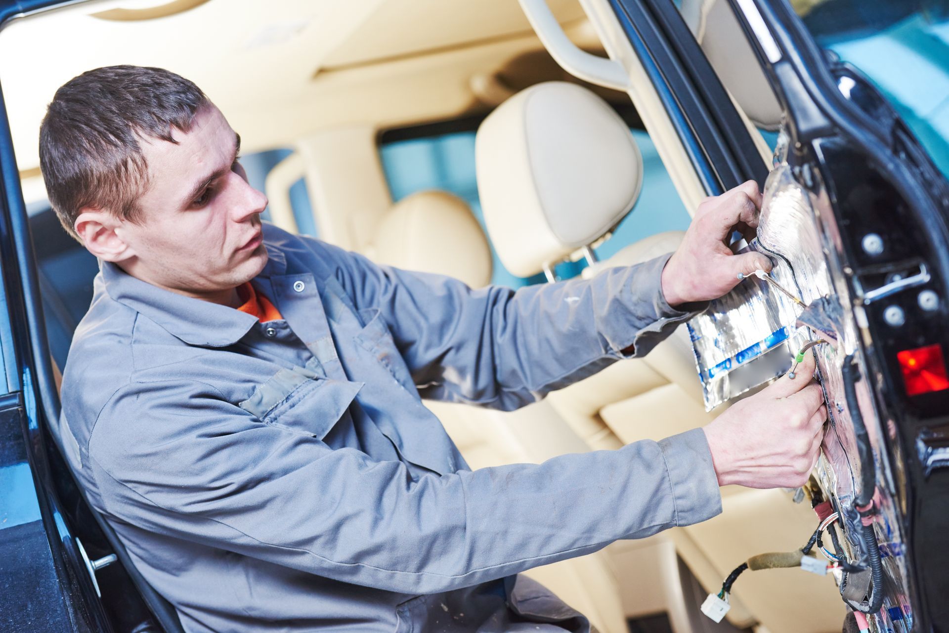 A man is working on the inside of a car.