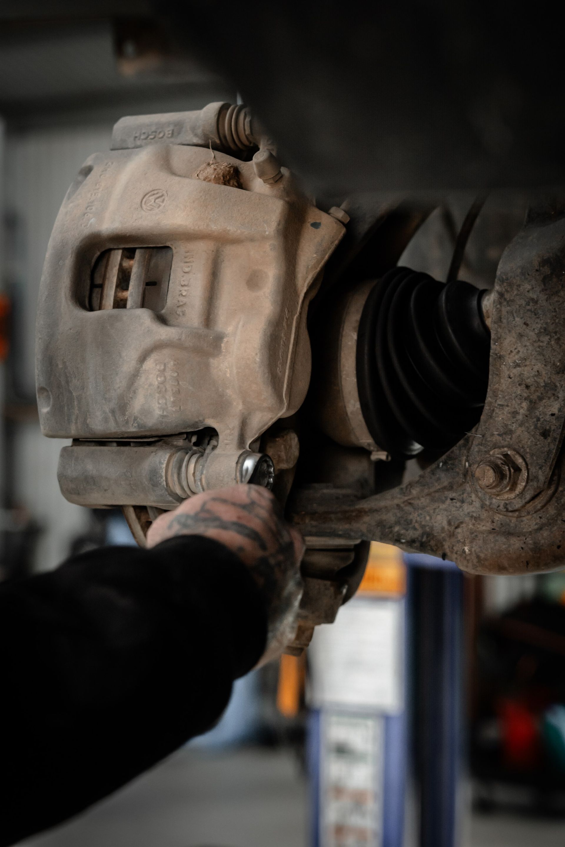 A mechanic unscrewing car bolt