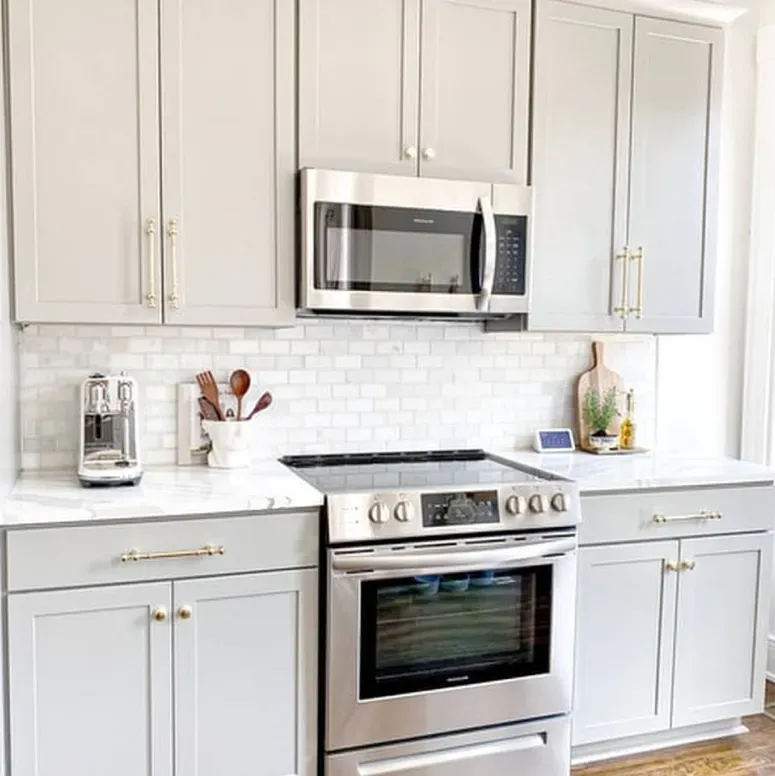 A kitchen with stainless steel appliances and white cabinets.