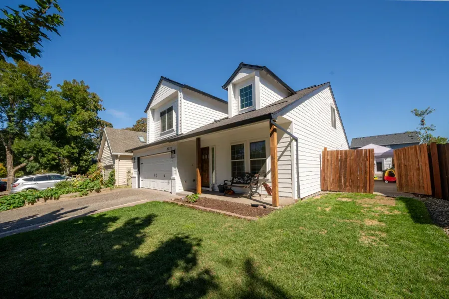 A white house with a wooden fence in front of it.