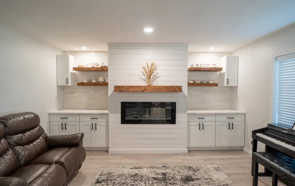 A living room with a fireplace , couch , piano and shelves.