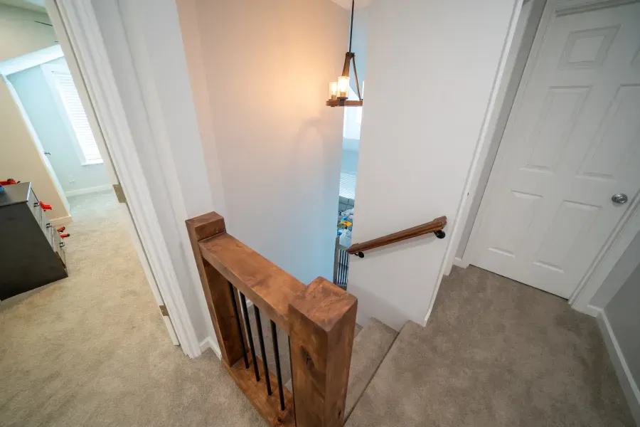 A wooden railing leading up to the second floor of a house.