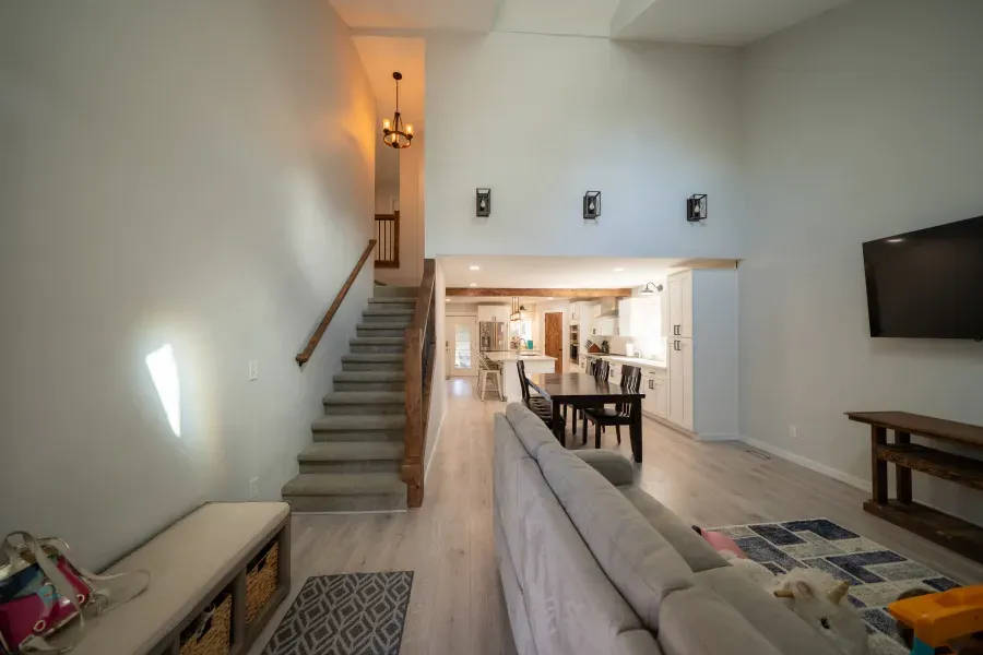 A living room with a couch and stairs leading up to the second floor