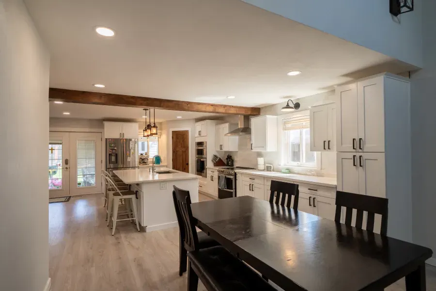 A kitchen and dining room in a house with a table and chairs.