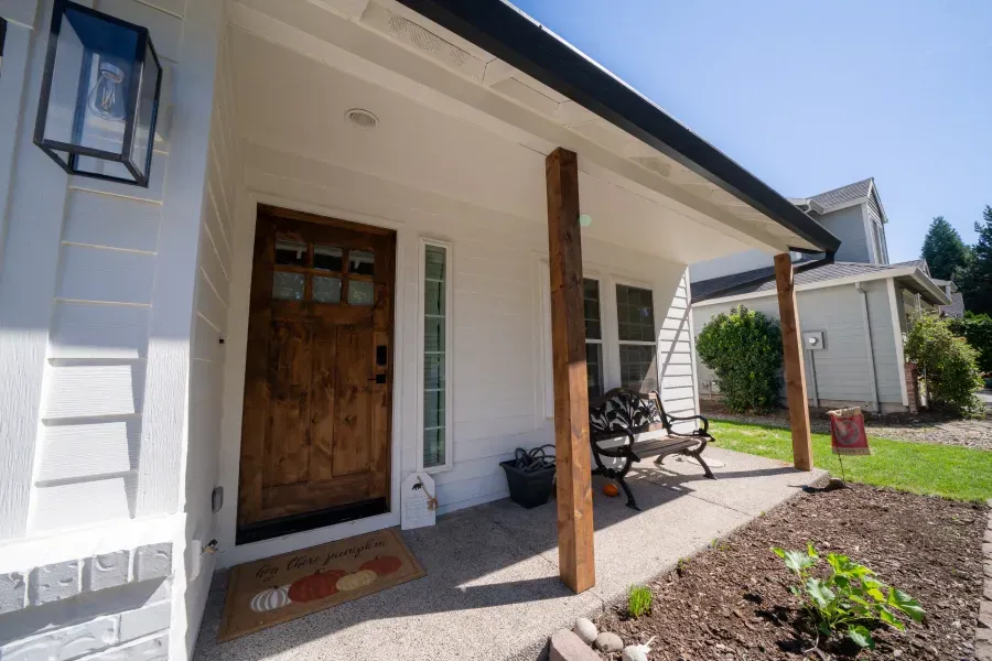 A white house with a porch and a wooden door