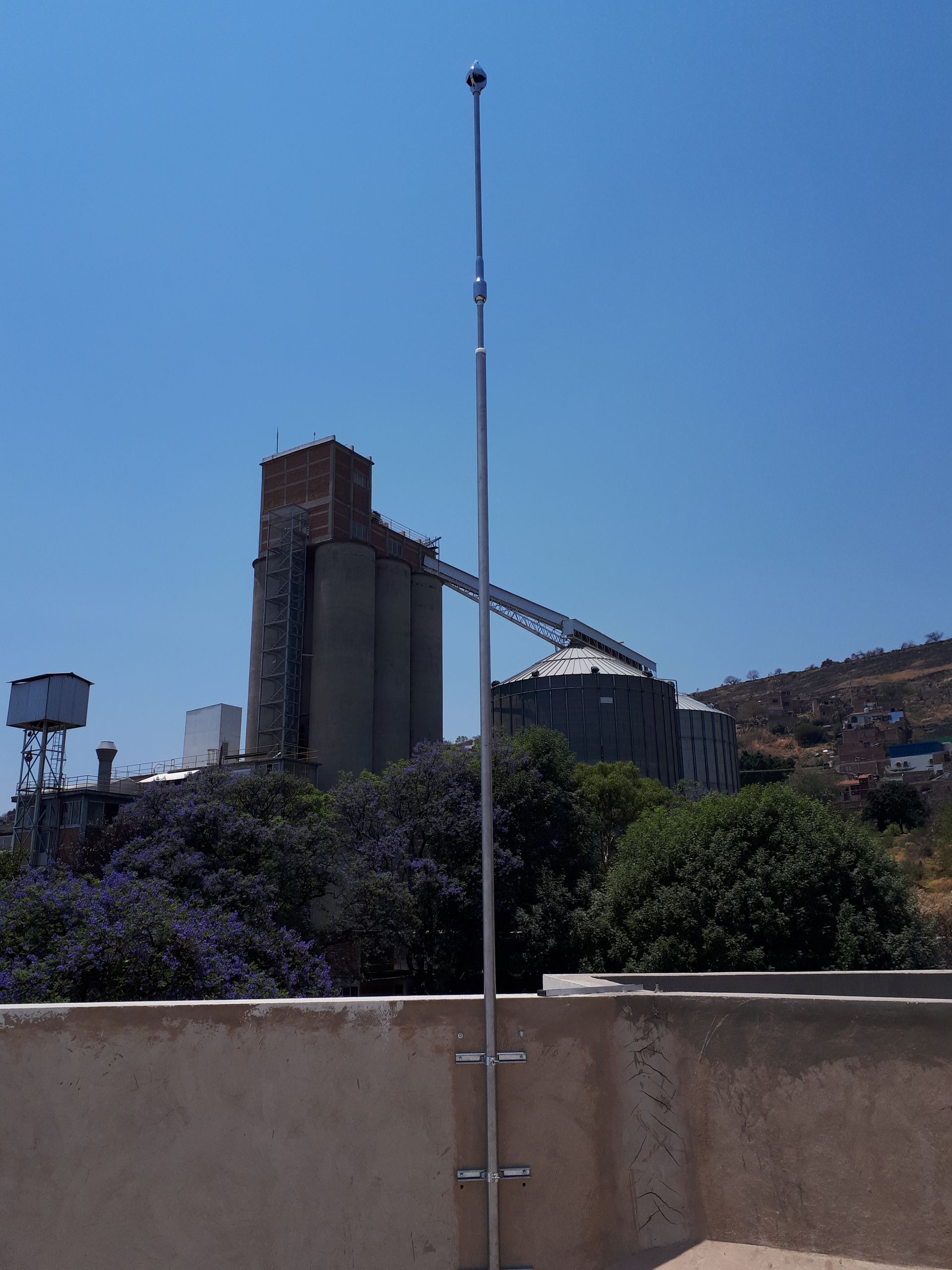 Una escalera está unida a un poste de metal frente a un edificio grande