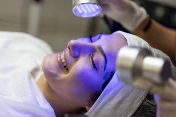 Doing blue light therapy on face