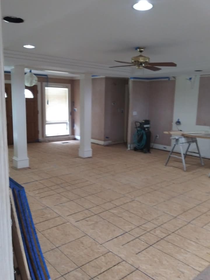 A large empty room with tile floors and a ceiling fan.