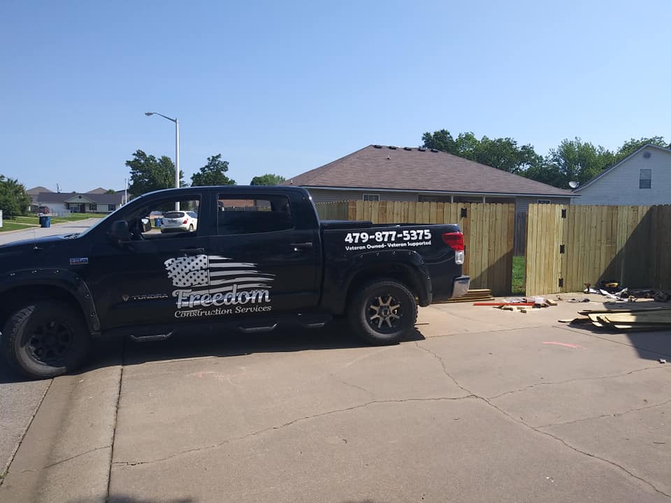 A freedom truck is parked in front of a house