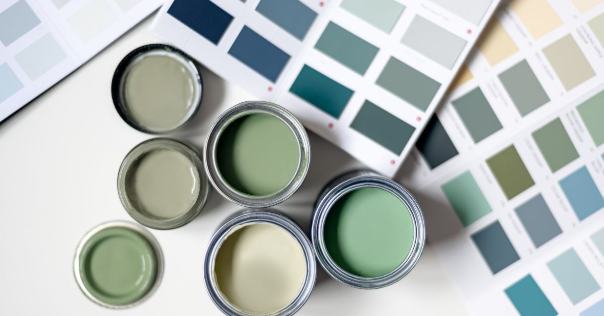 A bunch of cans of paint are sitting on top of a table.