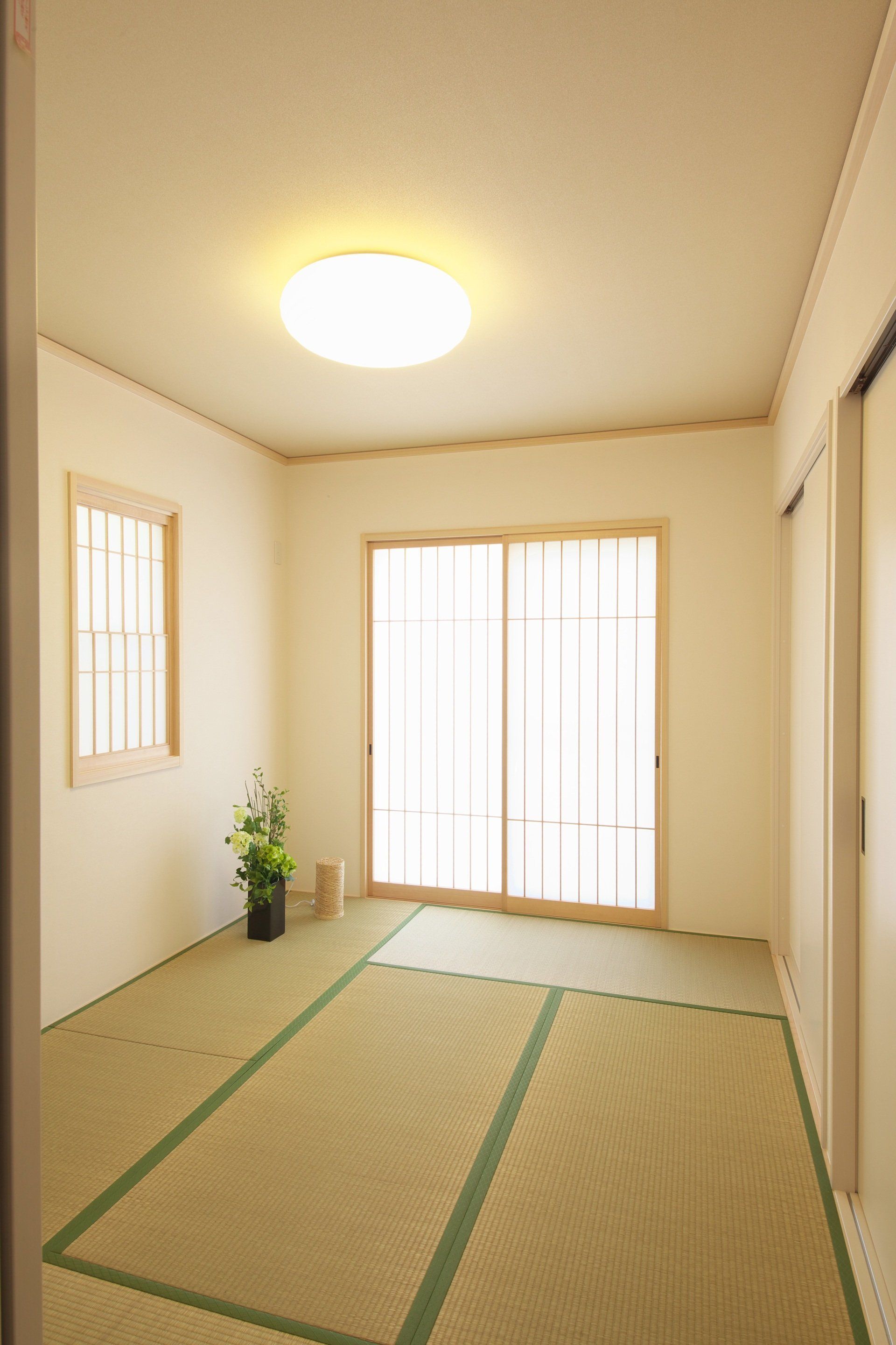 A room with a tatami mat and sliding glass doors.