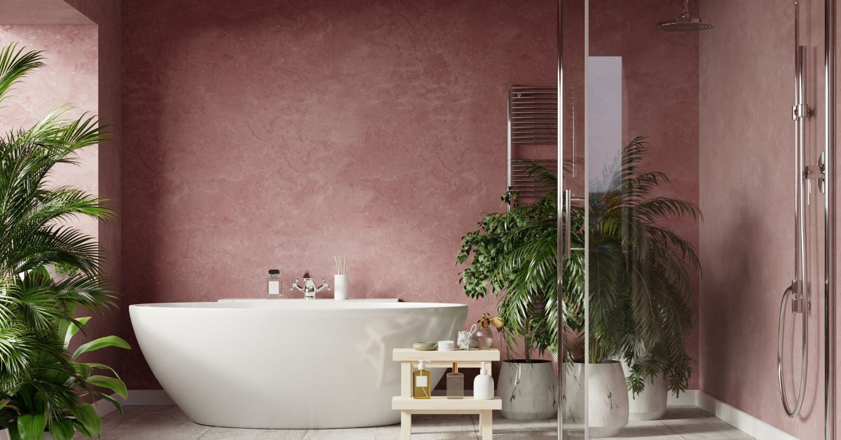 A bathroom with pink walls , a bathtub , and plants.