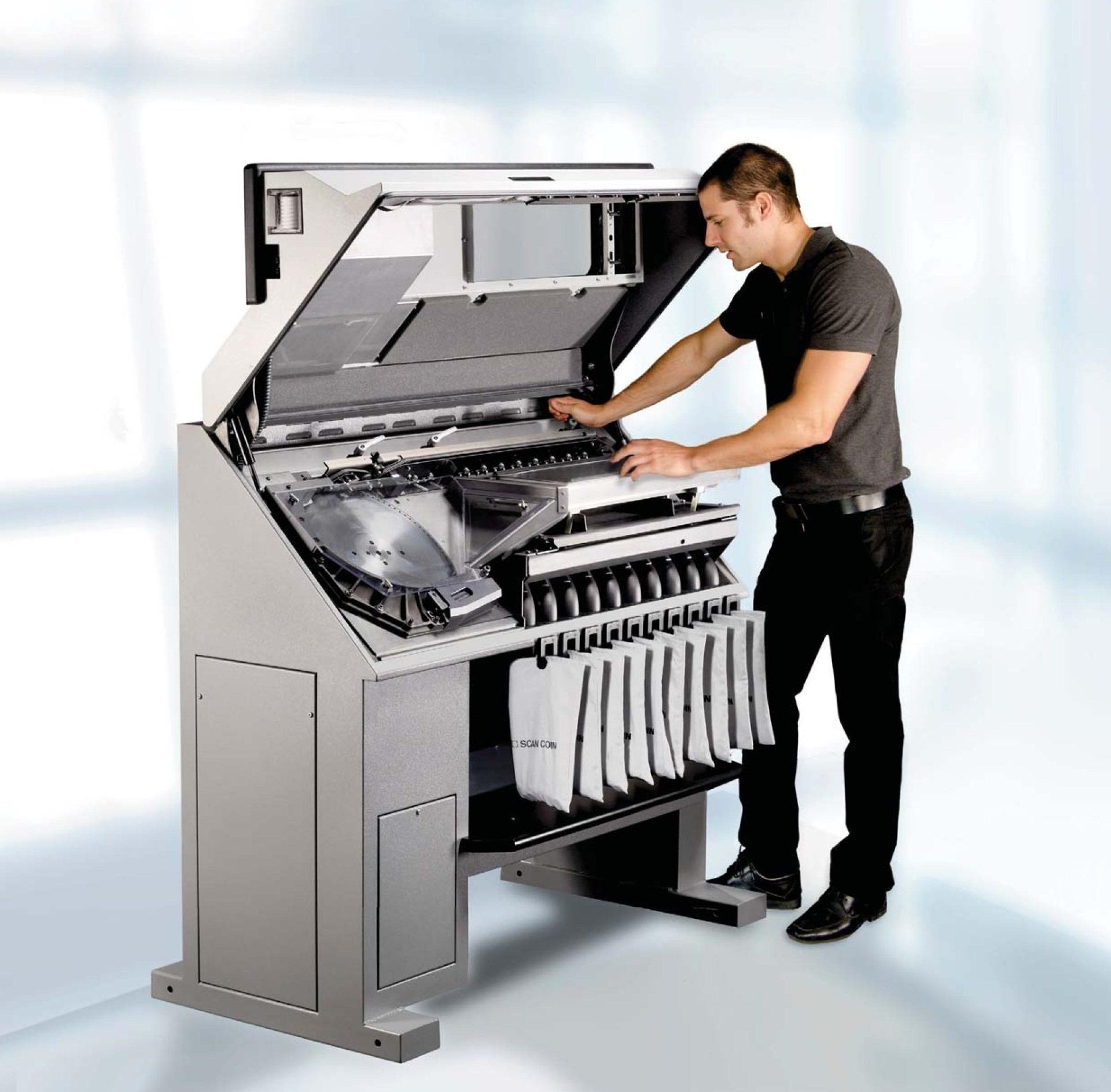 A man is working on a machine with the lid open