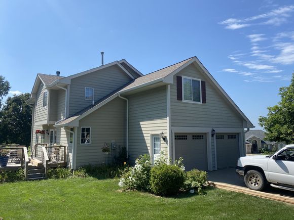 Professional painter applying clean coat to exterior home facade