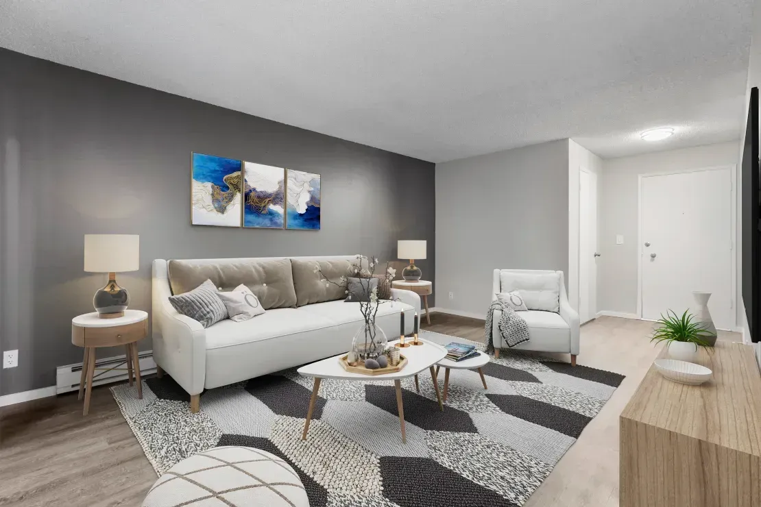 A living room with a couch , chairs , coffee tables and a rug.