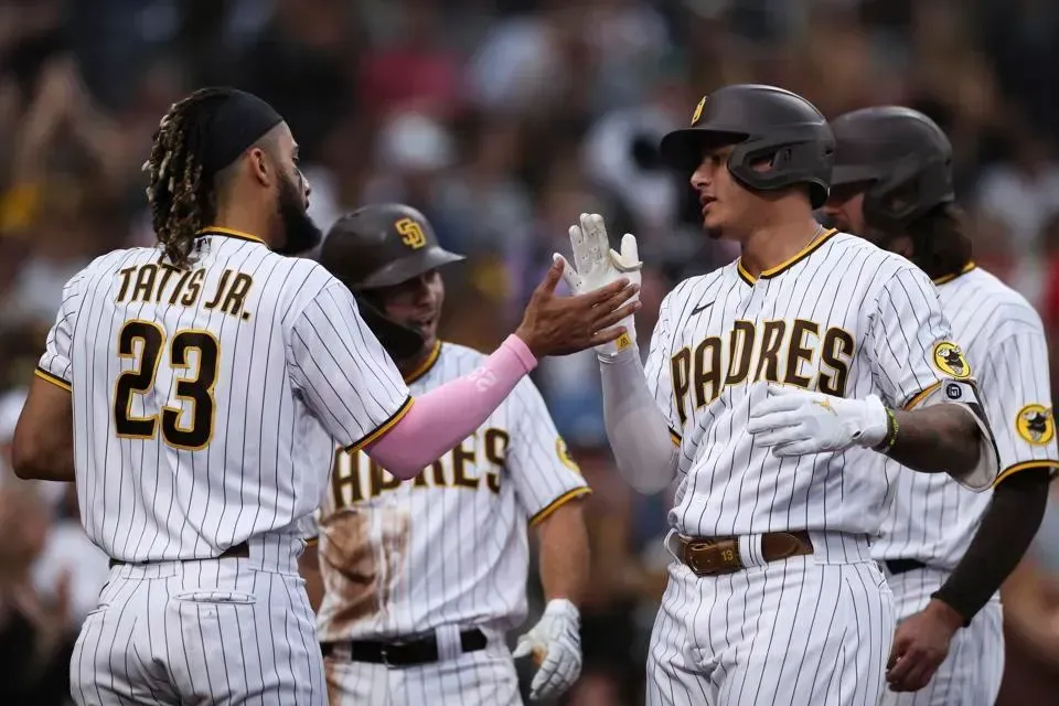 a group of baseball players are standing next to each other on a field .