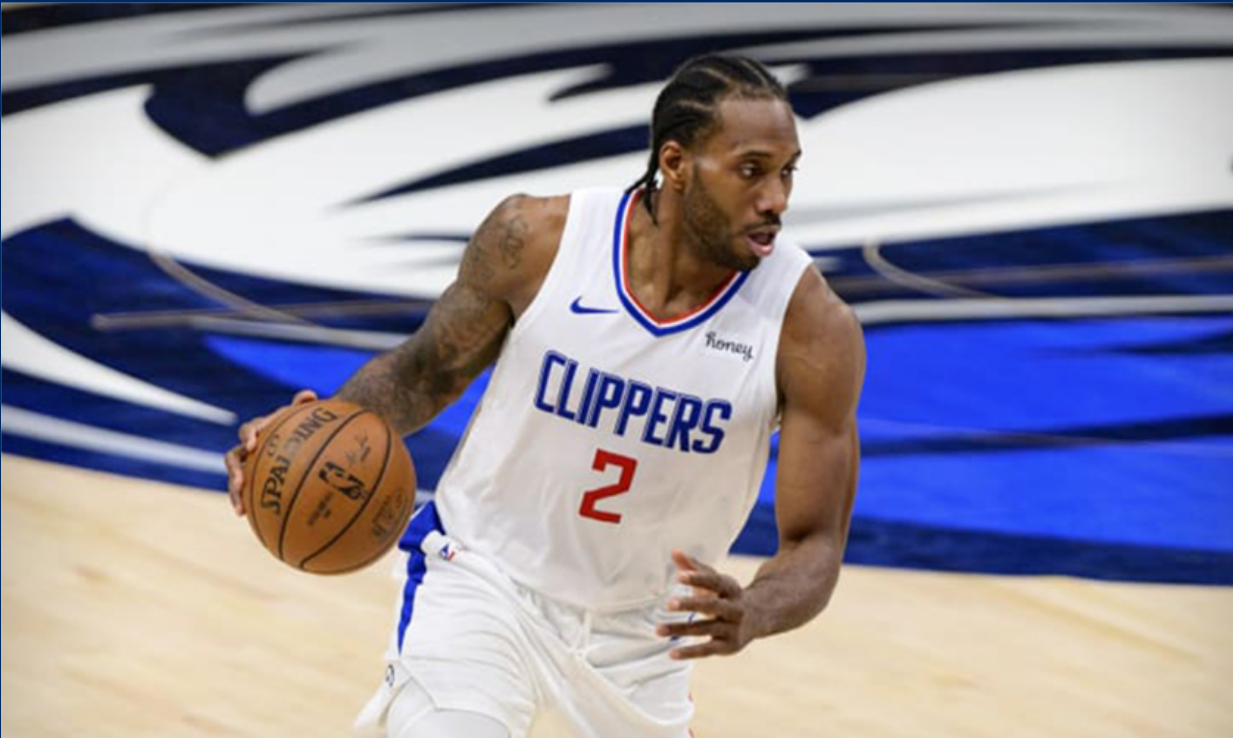 a man in a clippers jersey is dribbling a basketball on a court .