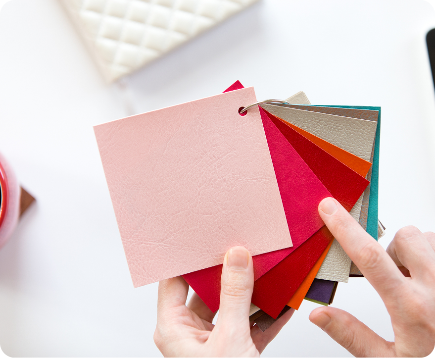 Hands holding a fan of pastel and bright color swatches for design selection