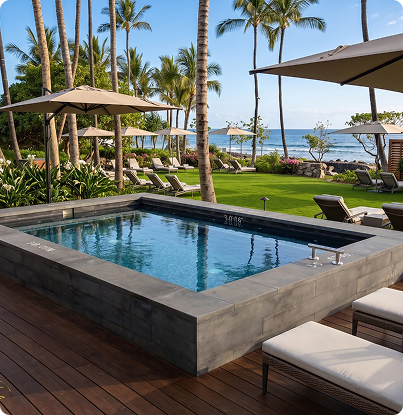 Luxury resort pool with lounge chairs, palm trees, and ocean view under umbrellas