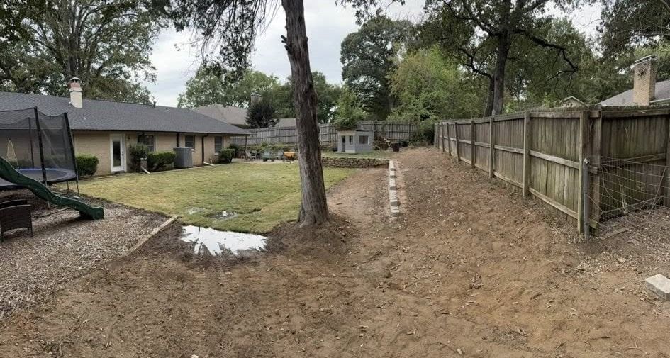 Backyard with grass, fence, trees, and a play set.