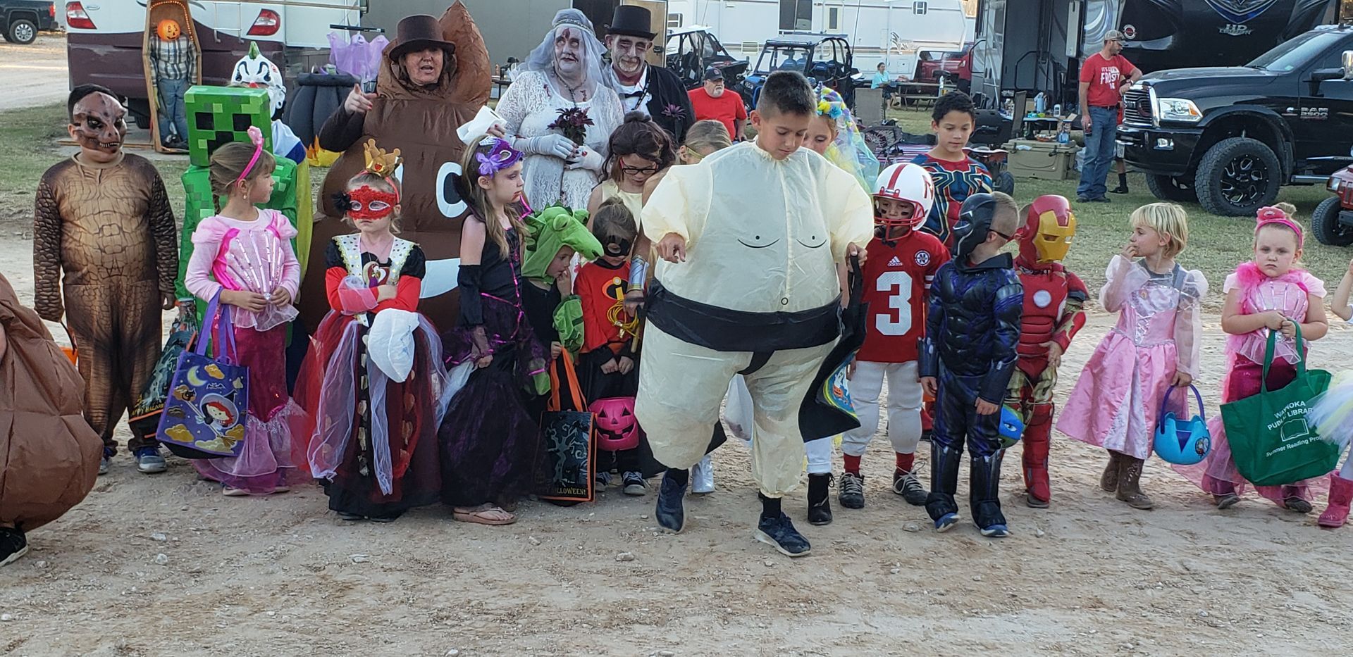 A group of children dressed in halloween costumes are posing for a picture.