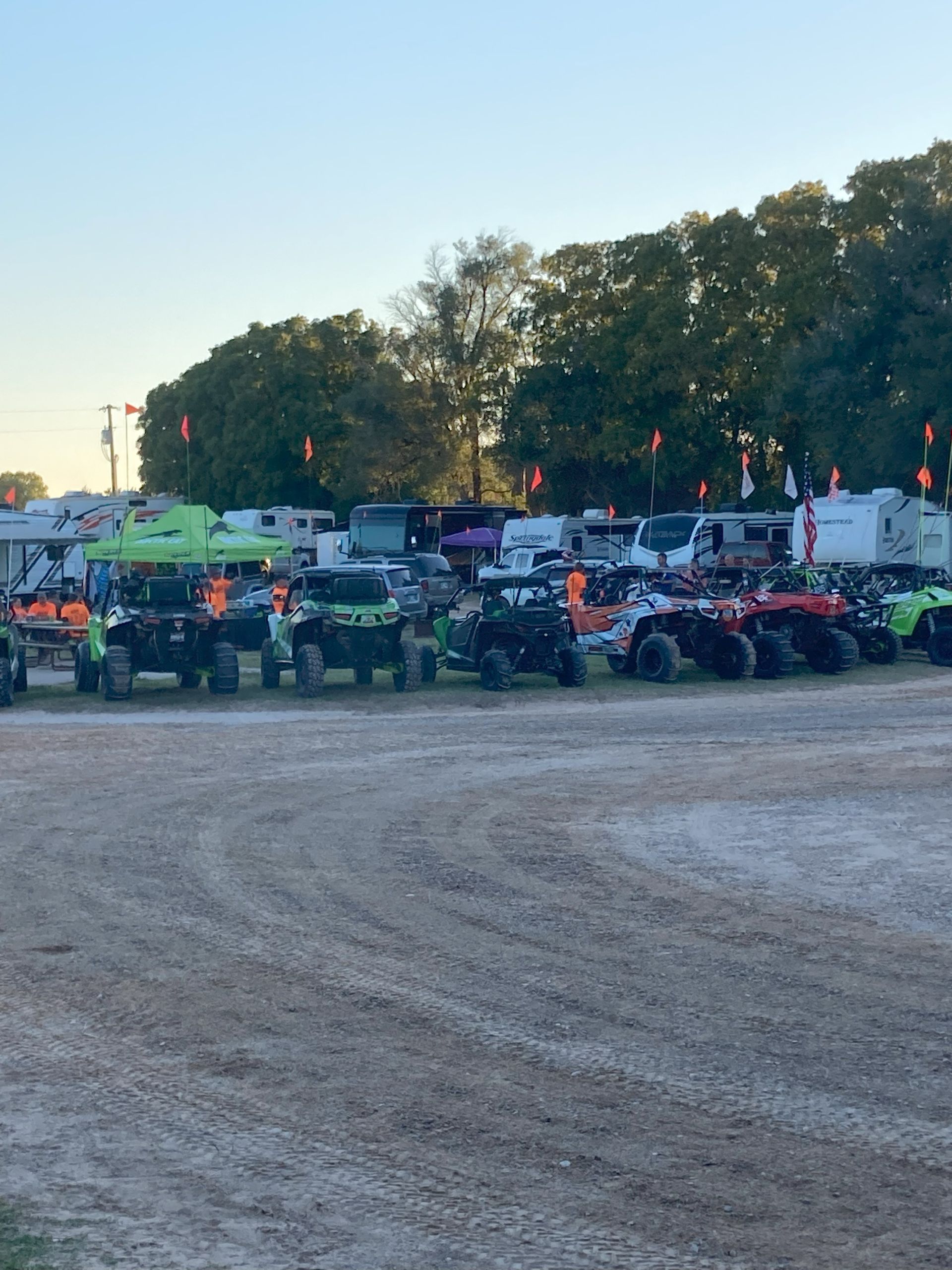 A row of atvs are parked in a dirt field