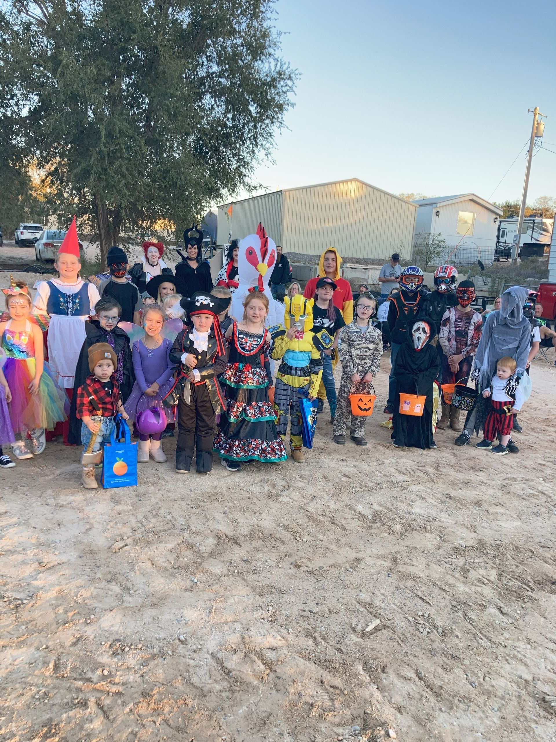 A group of children in halloween costumes are posing for a picture.