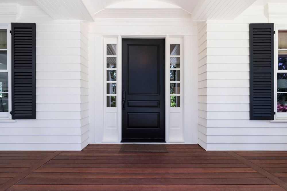 A White House With A Black Door And Black Shutters — Harris Design & Building Concepts In Cannonvale, QLD