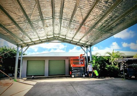 A Man On A Scissor Lift Is Working On A Roof Over A Garage — Harris Design & Building Concepts In Jubilee Pocket, QLD
