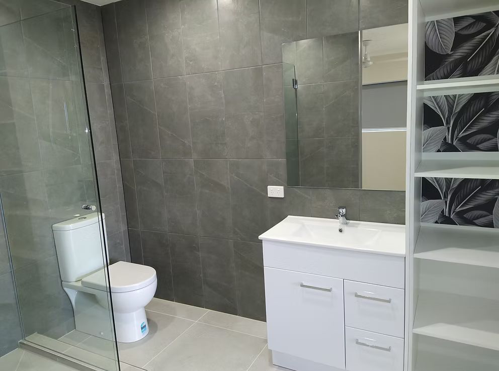 A Walk In Closet With Sliding Doors In A Hallway — Harris Design & Building Concepts In Airlie Beach, QLD