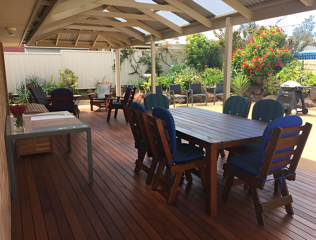 A Wooden Deck With A Table And Chairs Under A Canopy — Harris Design & Building Concepts In Jubilee Pocket, QLD
