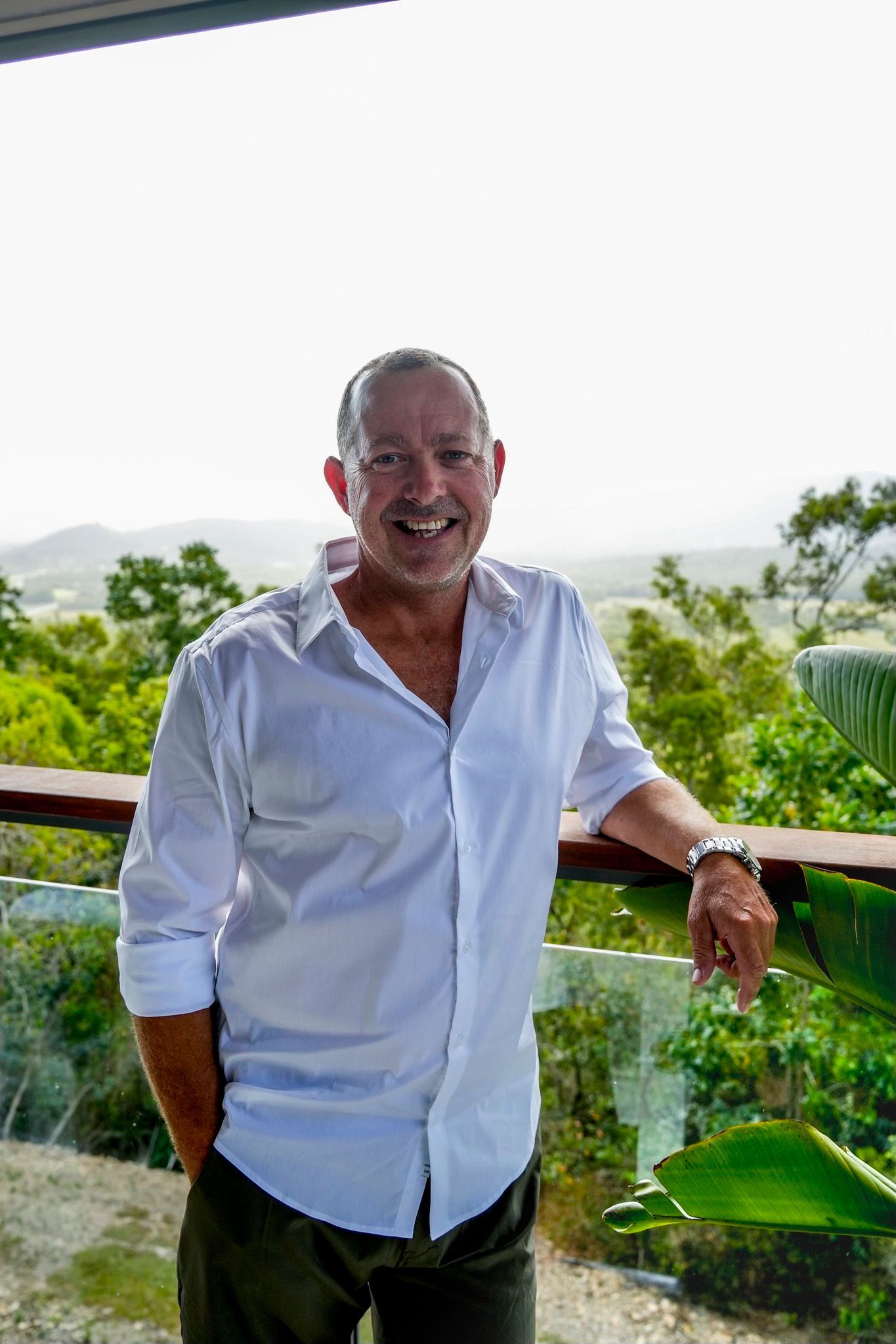 A Living Room With A White Sectional Couch And A Black Chair — Harris Design & Building Concepts In Jubilee Pocket, QLD