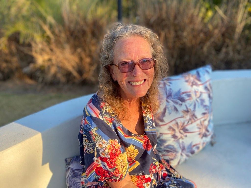 A Living Room With A White Sectional Couch And A Black Chair — Harris Design & Building Concepts In Jubilee Pocket, QLD