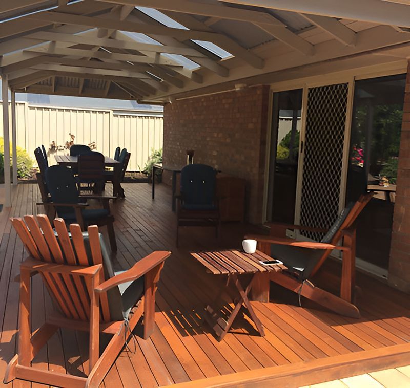 A Wooden Deck With Chairs And A Small Table — Harris Design & Building Concepts In Jubilee Pocket, QLD