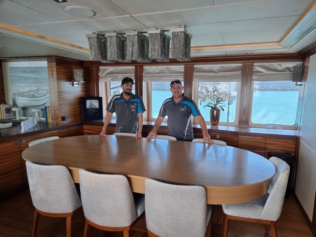 A Living Room With A White Sectional Couch And A Black Chair — Harris Design & Building Concepts In Jubilee Pocket, QLD