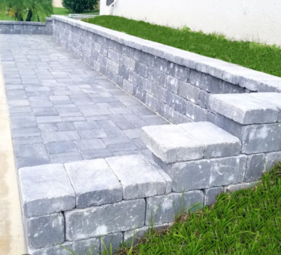 A brick wall is sitting on top of a lush green field.