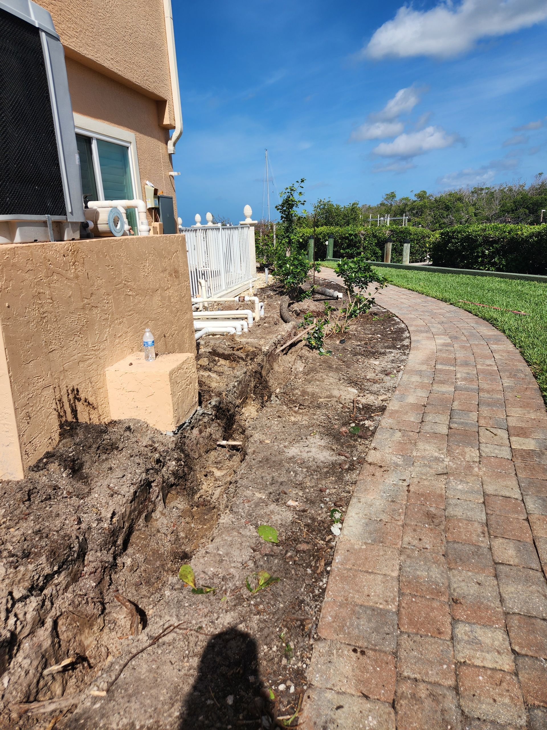 A brick walkway is being built in front of a house.